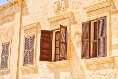 Picture of a sunlit facade of a Maltan building.